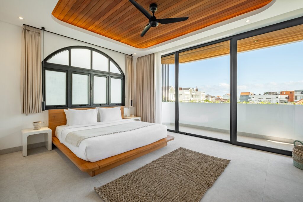 Bedroom with arched window and rooftop view at Villa Tre