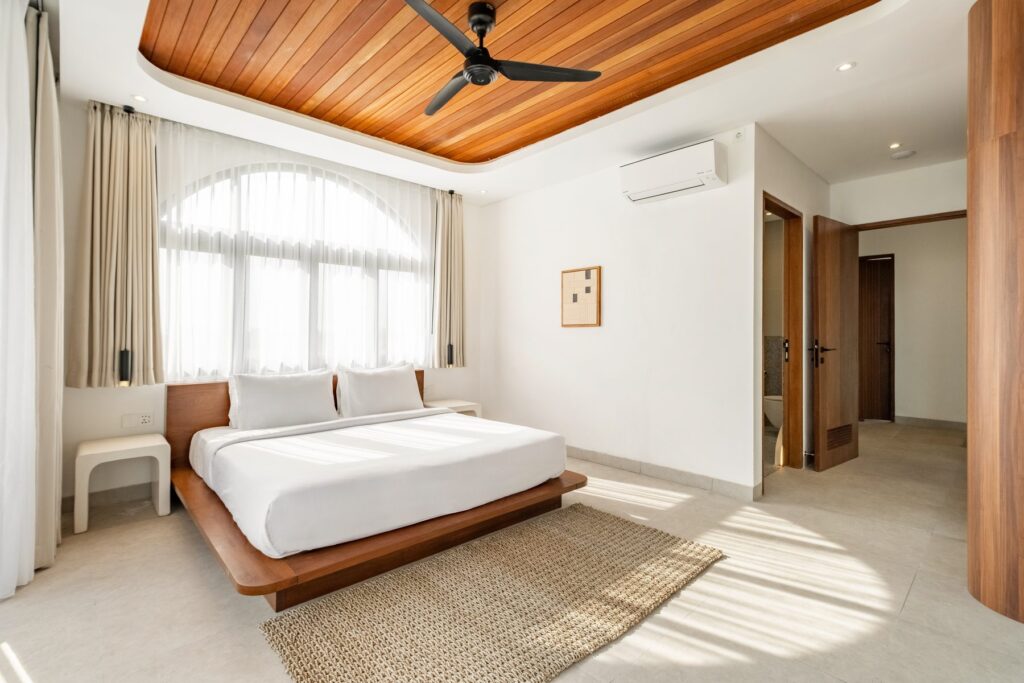 King bedroom with arched window and timber ceiling at Villa Quattro