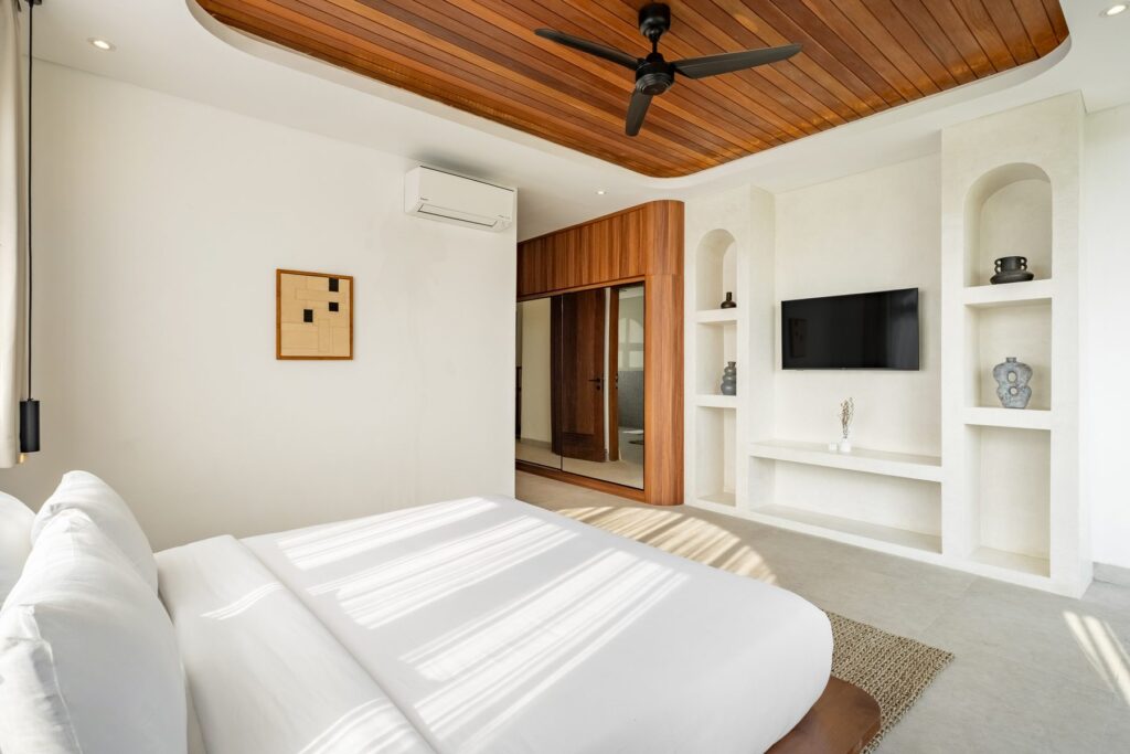Bedroom with built-in shelving and smart TV at Villa Quattro