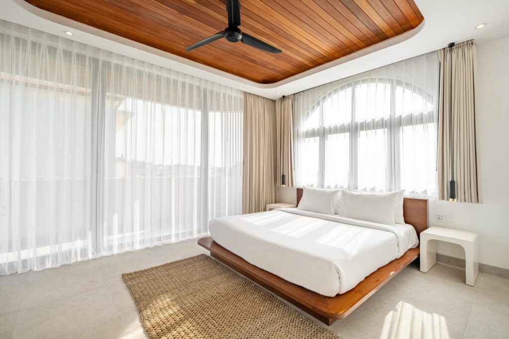 Bright king bedroom with arched windows at Villa Quattro