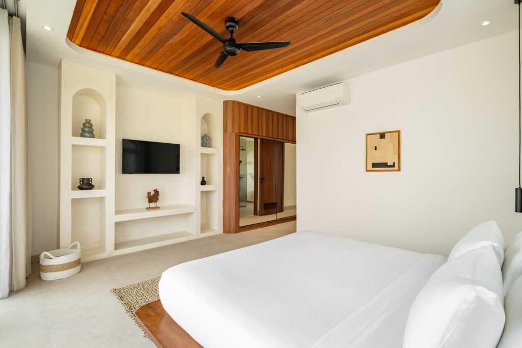 Bedroom with smart TV and built-in shelving at Villa Quattro