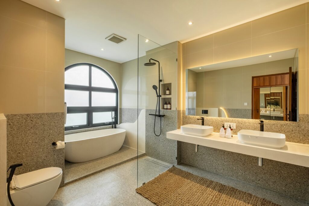 Ensuite bathroom with freestanding bathtub and rain shower at Villa Quattro